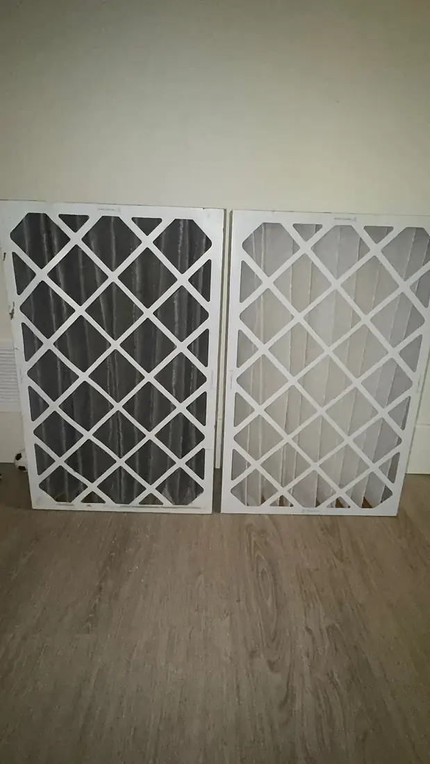 A dirty furnace filter beside a fresh one after a maintenance visit