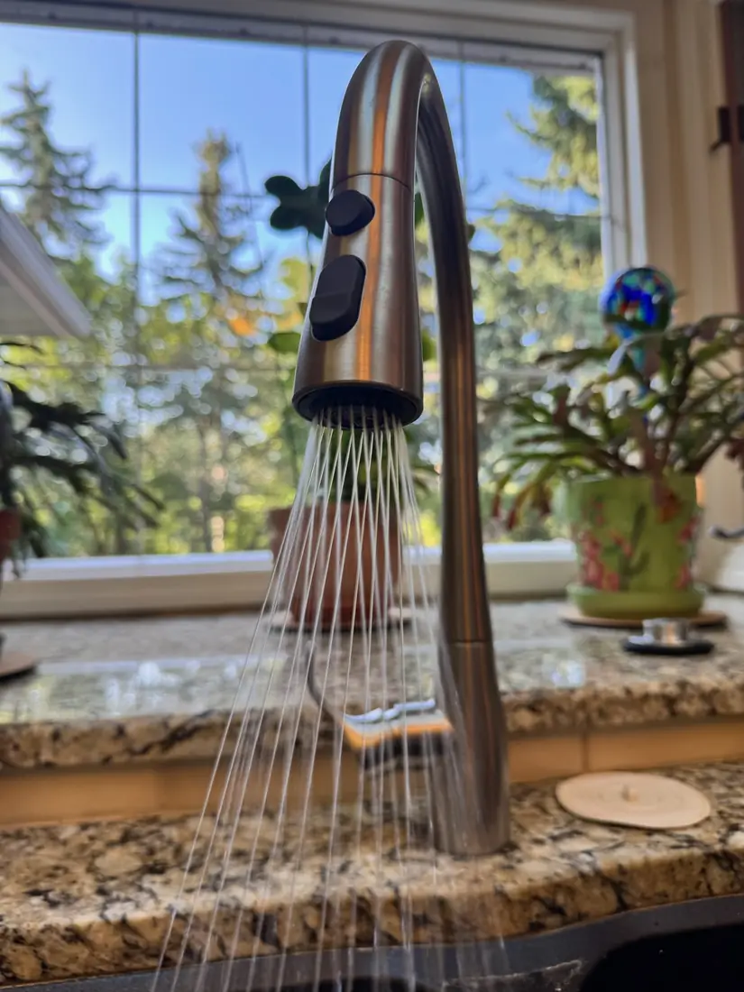 Newly installed pull-down kitchen faucet running at full flow