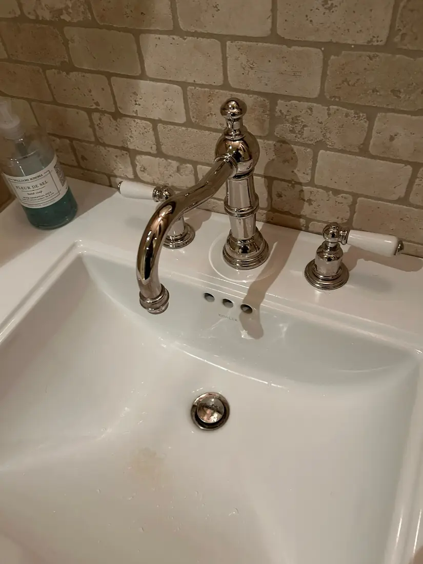 Kohler widespread lavatory faucet finished against a stone backsplash