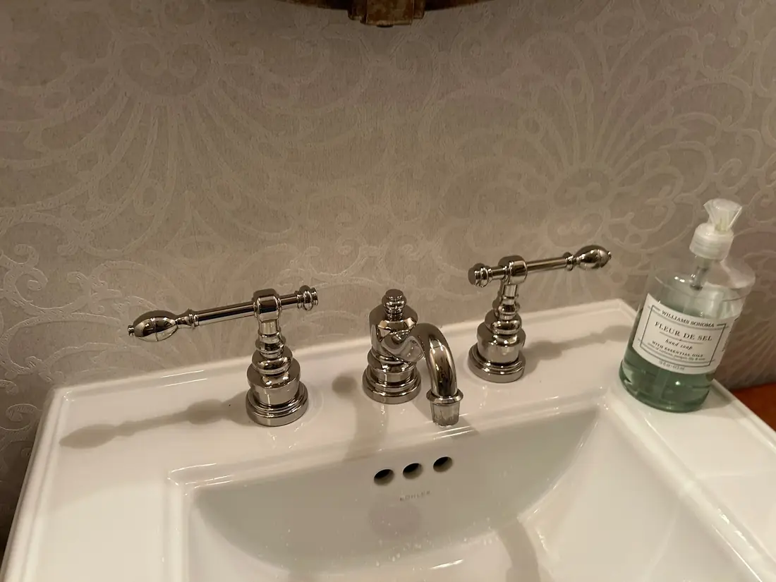 Kohler polished nickel widespread faucet on a white vanity basin