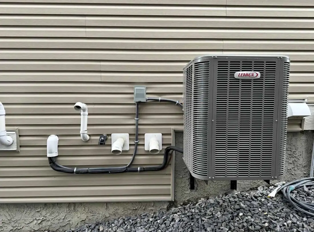 Lennox central air conditioner installed on a Calgary home with line set and electrical disconnect