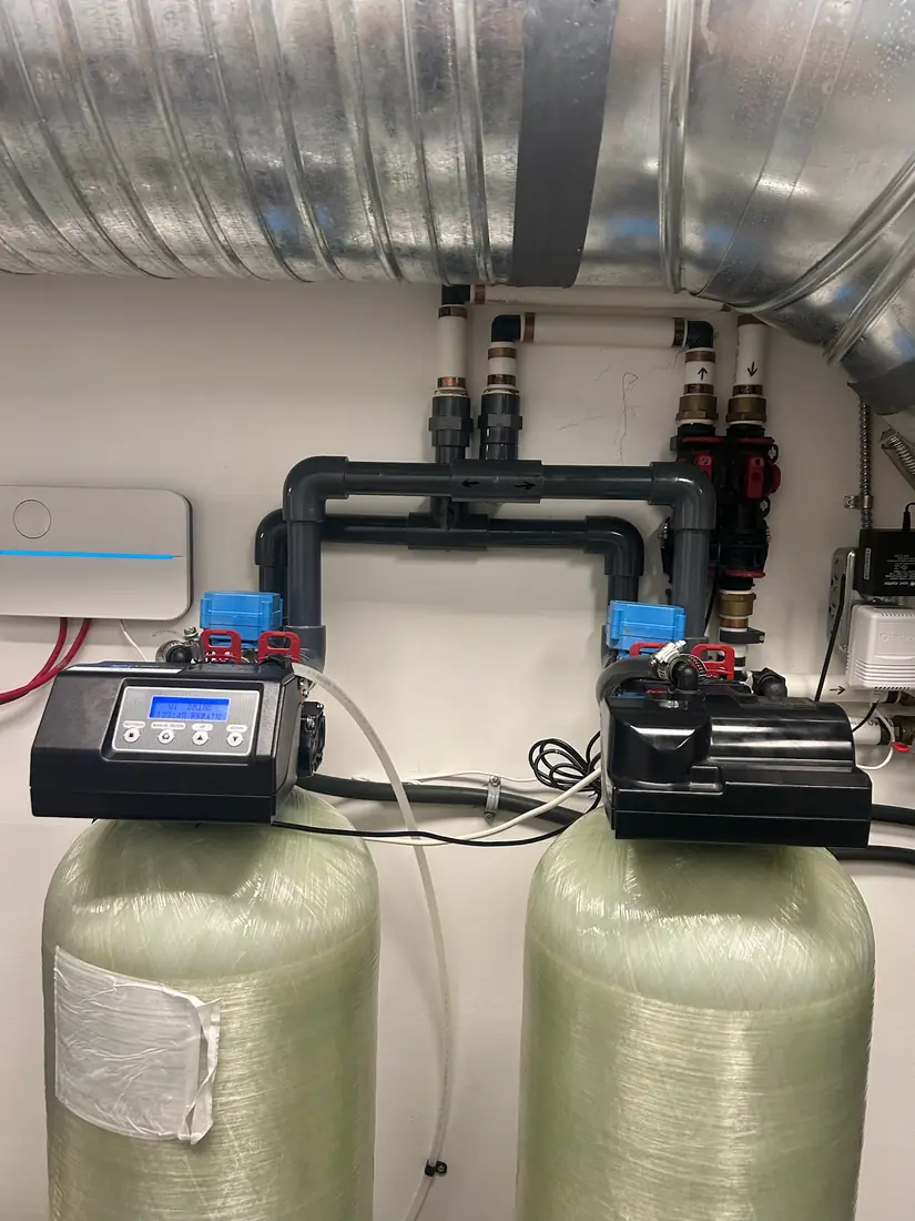 Twin water softener tanks with PVC manifold and bypass valves
